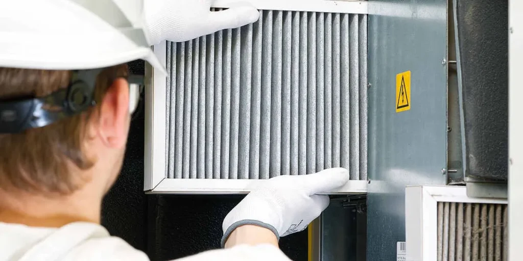 Technician replacing HVAC air filter