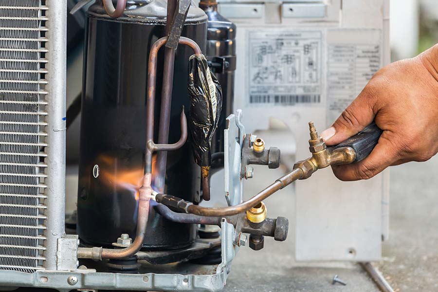 Technician repairing AC compressor